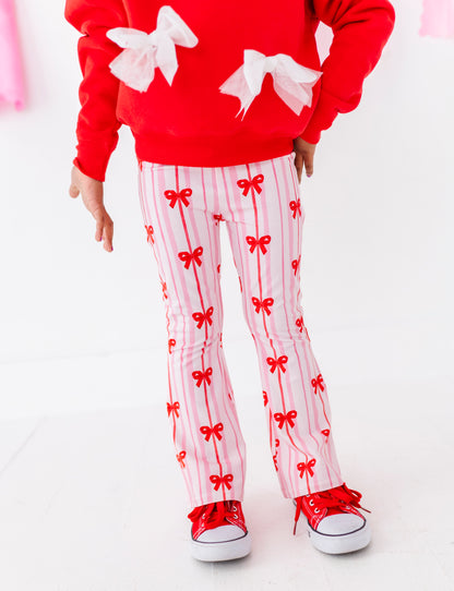 Detail view of red bow ribbon print on bamboo cotton children’s pants