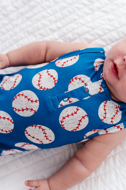 Baby wearing a blue bamboo outfit with baseball pattern on a white background