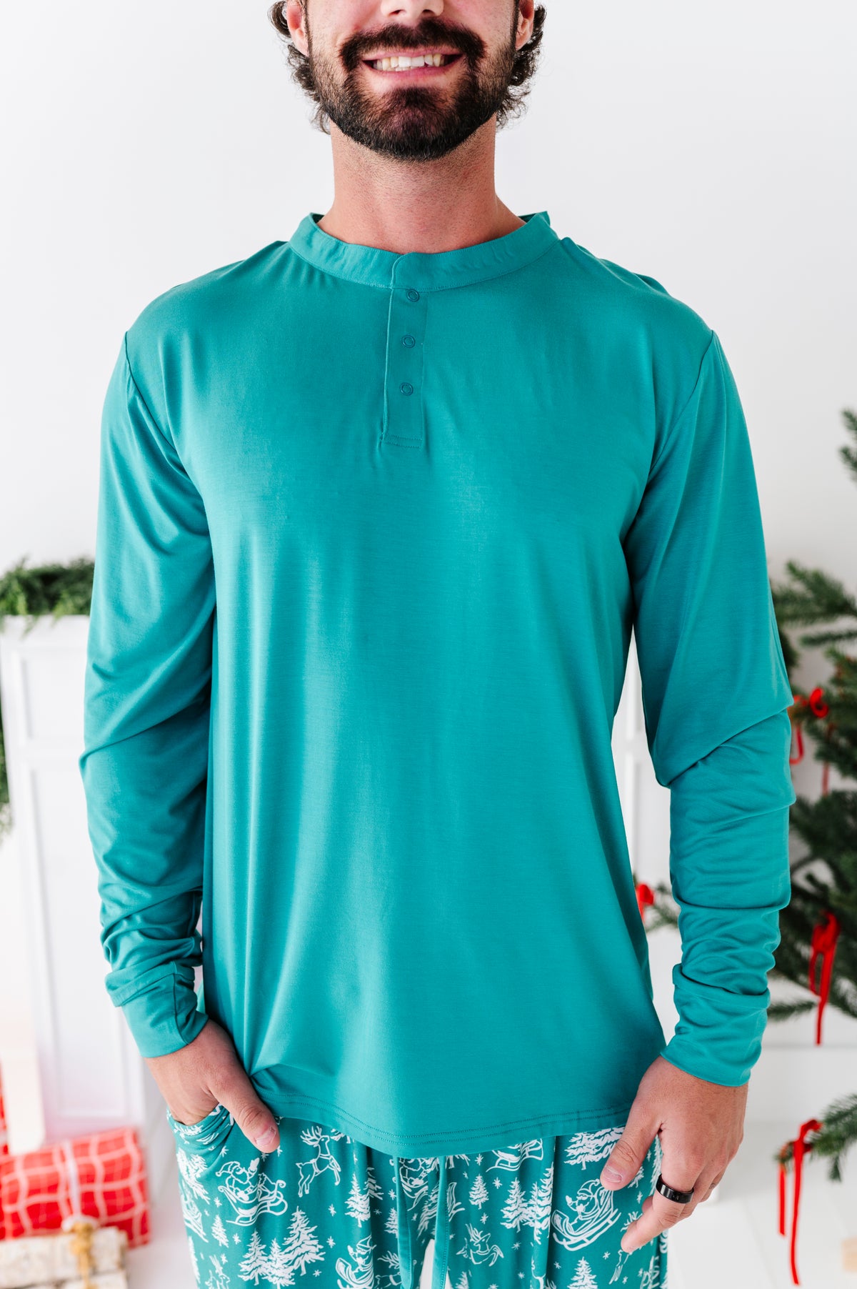 A close-up photo of a man wearing a green henley top. The top is made of bamboo material and perfect for the Christmas season 