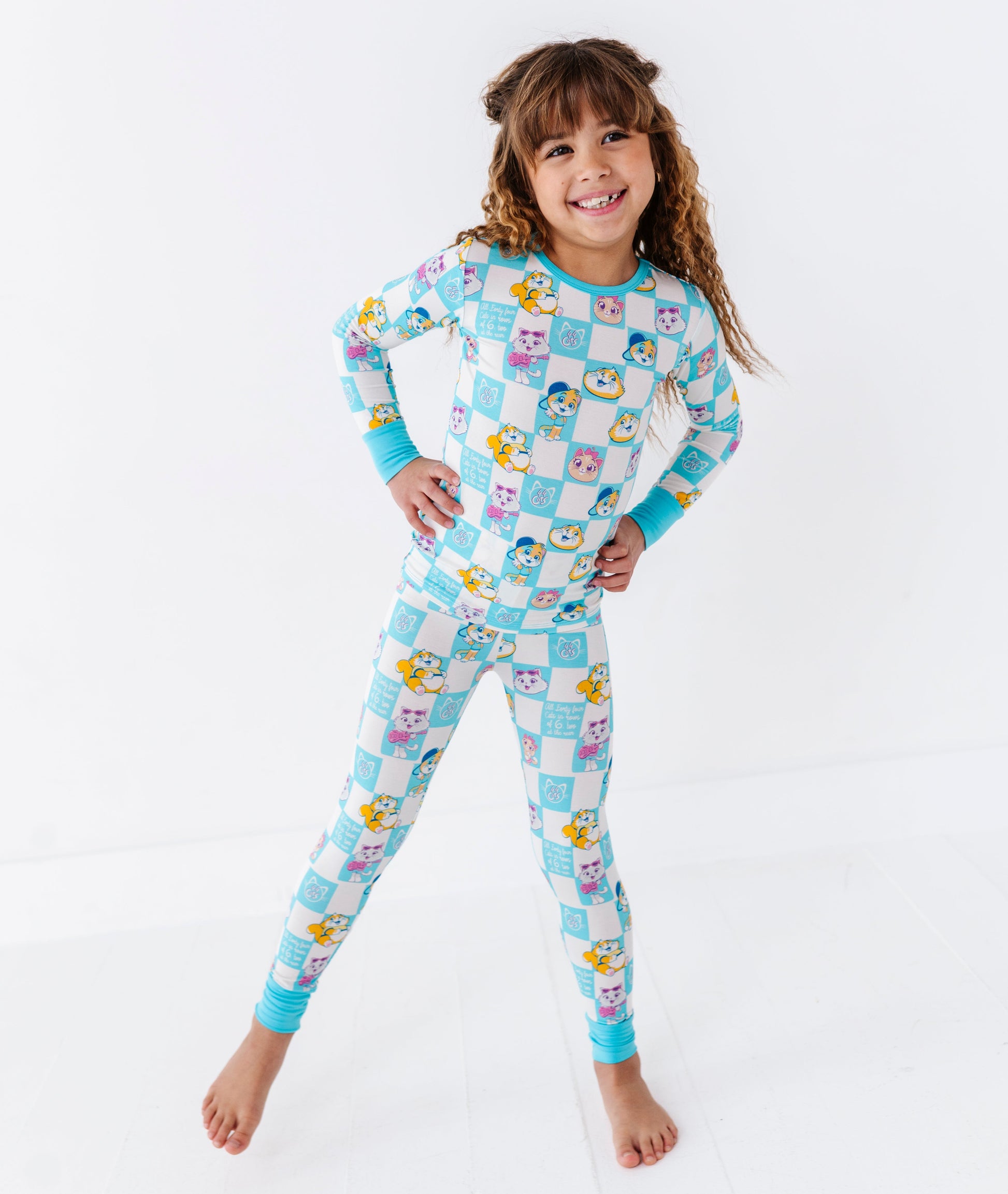 Child wearing a colorful checkered 44 CATS™ bamboo pajama set on a white background