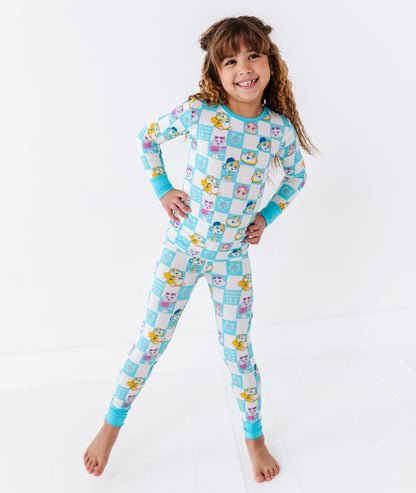 Child wearing a colorful checkered 44 CATS™ bamboo pajama set on a white background