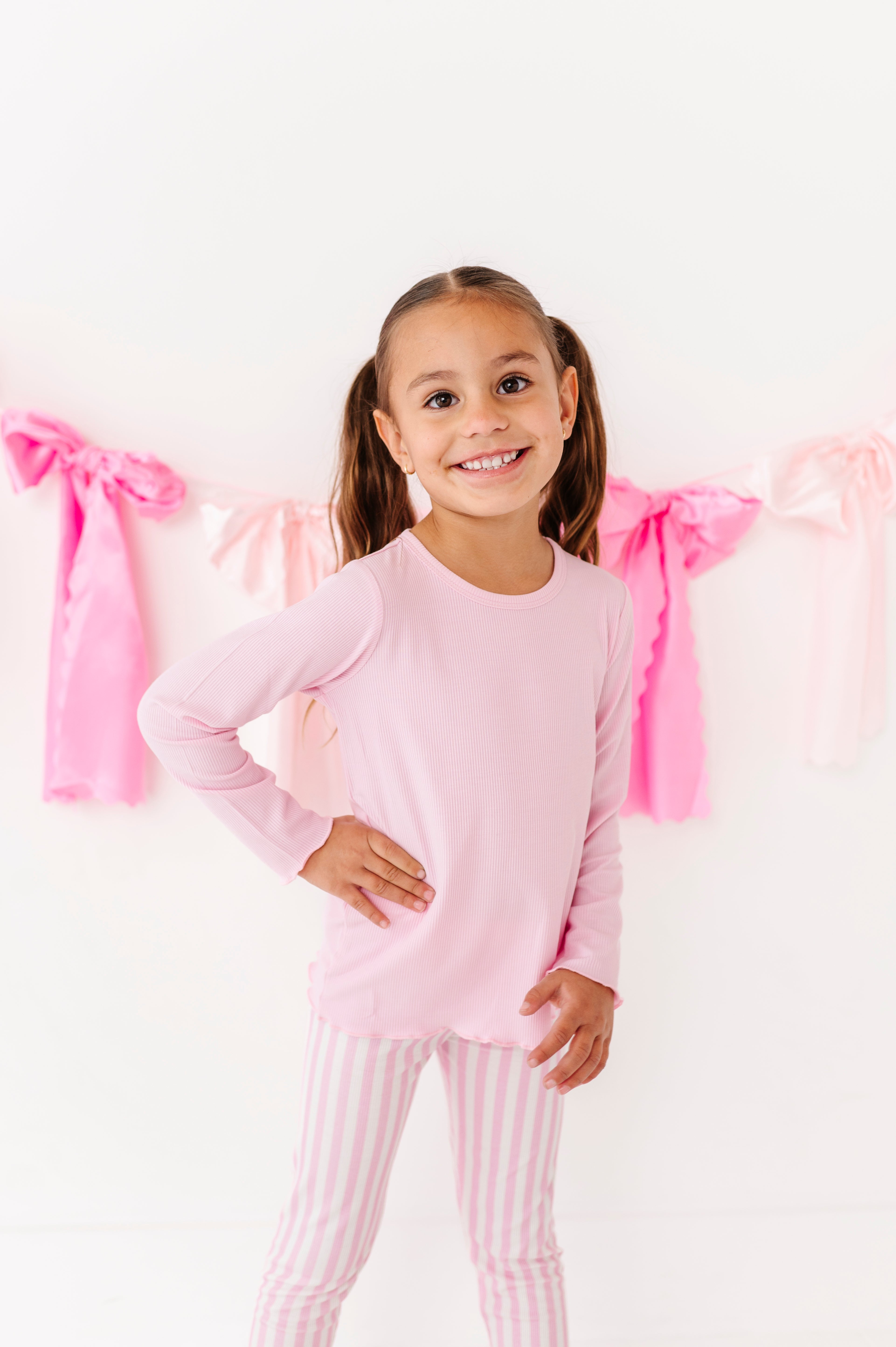 Toddler girl wearing a pink ribbed long sleeve top with lettuce hem 