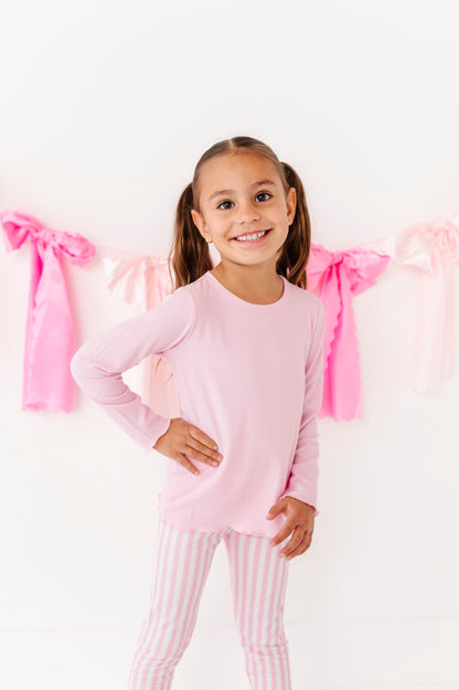 Toddler girl wearing a pink ribbed long sleeve top with lettuce hem 