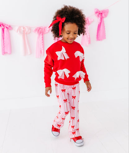 Child styled in Birdie Bean ruby ribbons pants with matching red sweatshirt