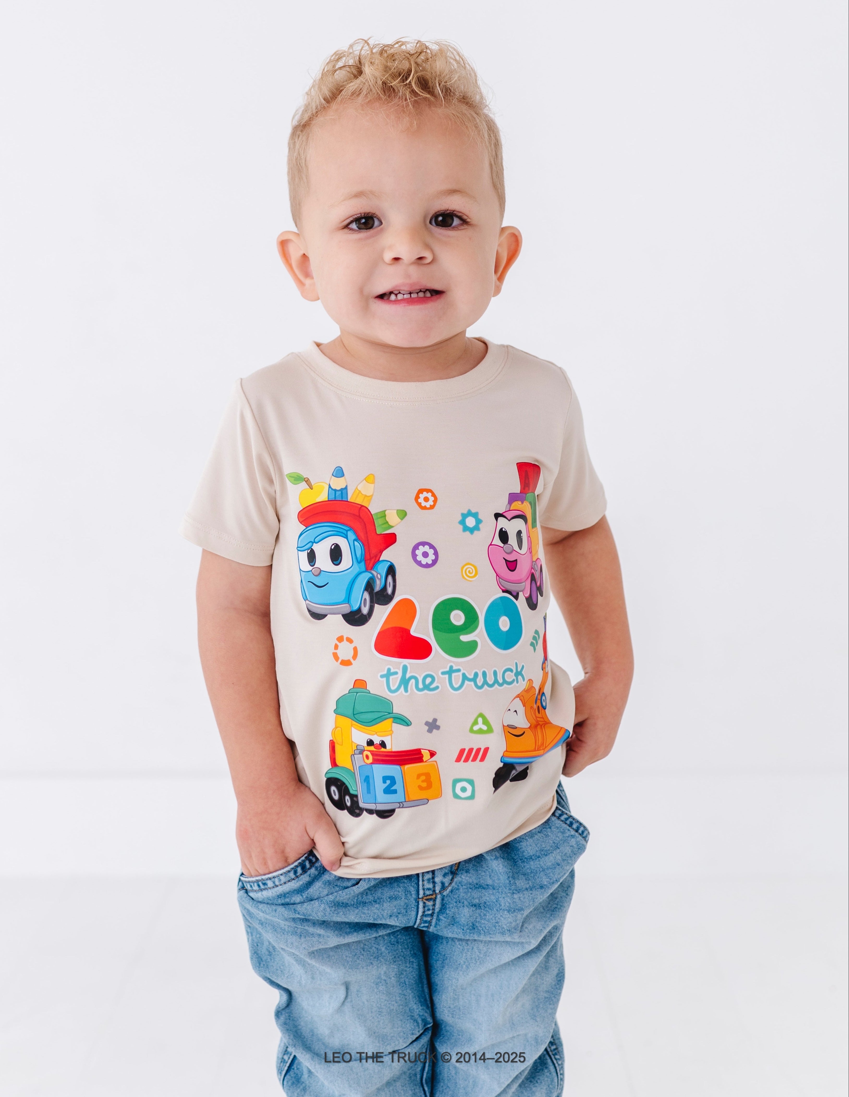 Little boy wearing a bamboo t-shirt with Leo the Truck graphic on a white background