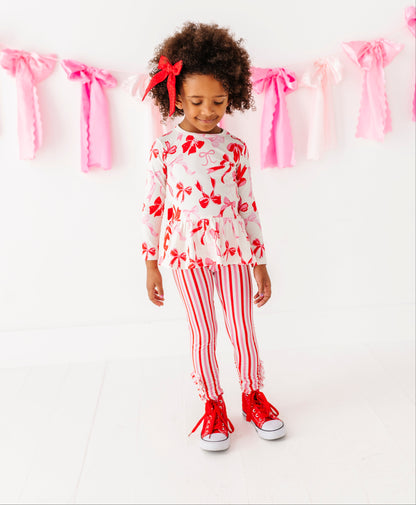 Toddler wearing Blushing Bows bamboo cotton peplum top with pink and red bow print