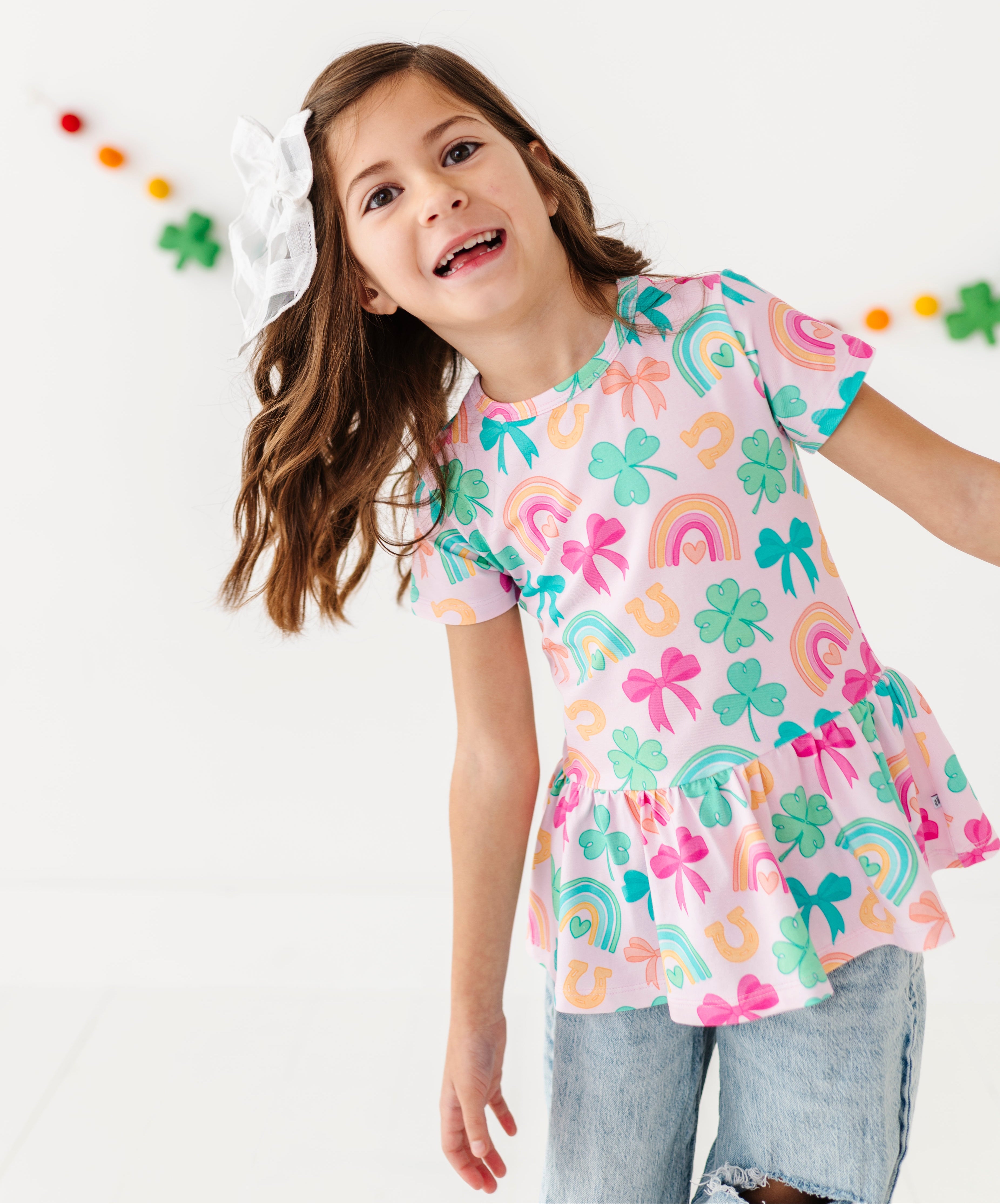 Young girl wearing a St. Patrick's themed bamboo peplum top with a white background