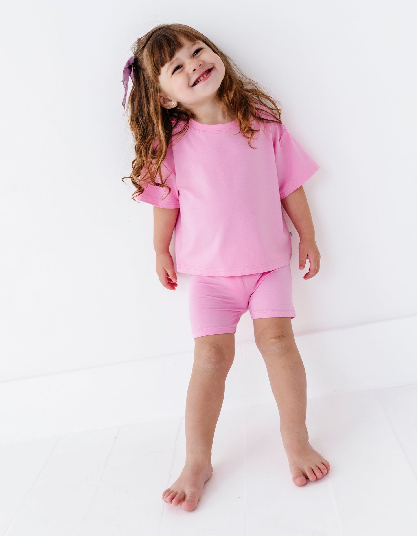Child wearing a pink bamboo outfit on a white background