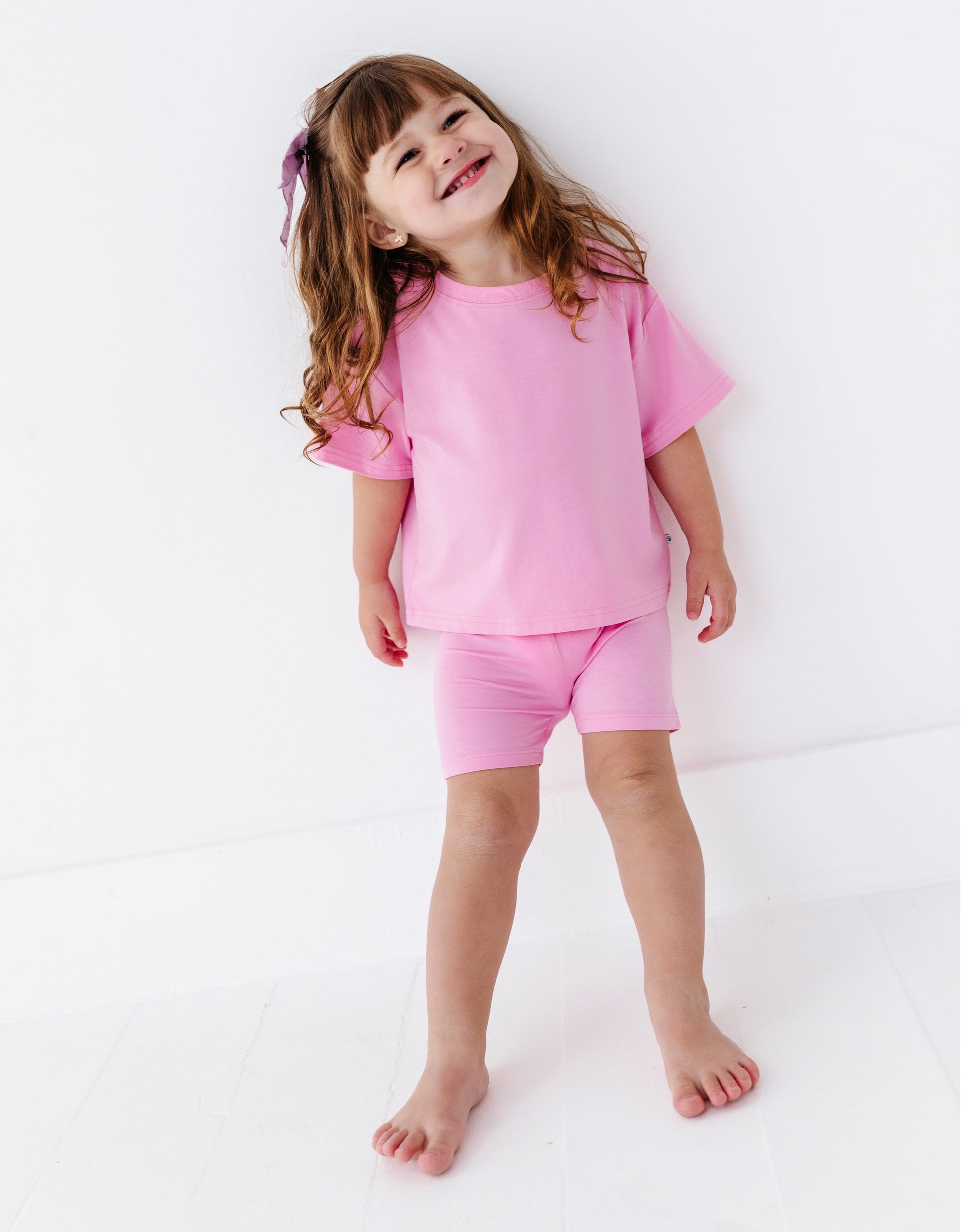 Child wearing a pink bamboo outfit on a white background