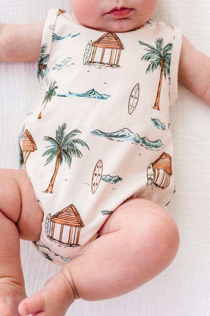 Baby wearing a sleeveless onesie with beach-themed print