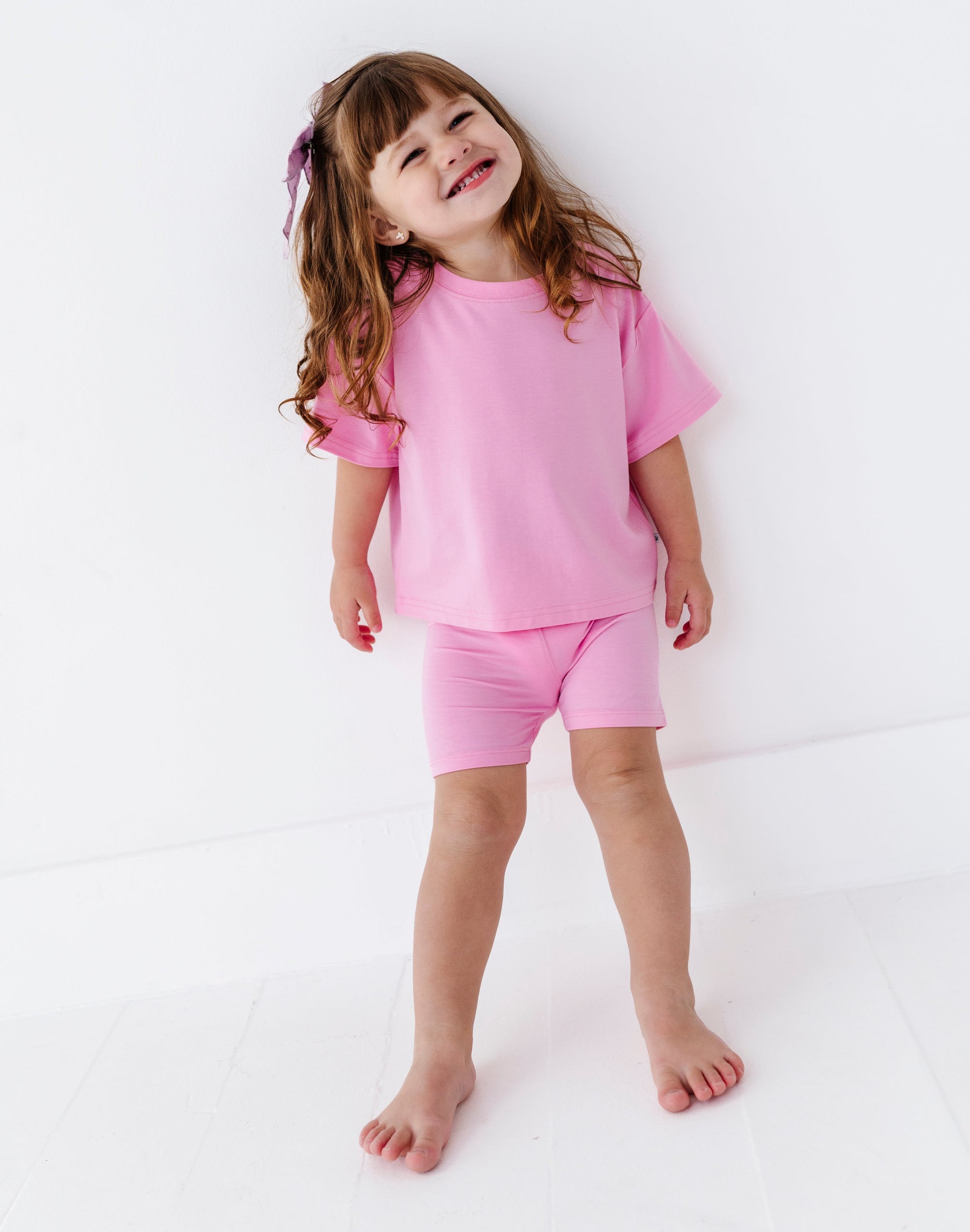 Child wearing a pink outfit on a white background