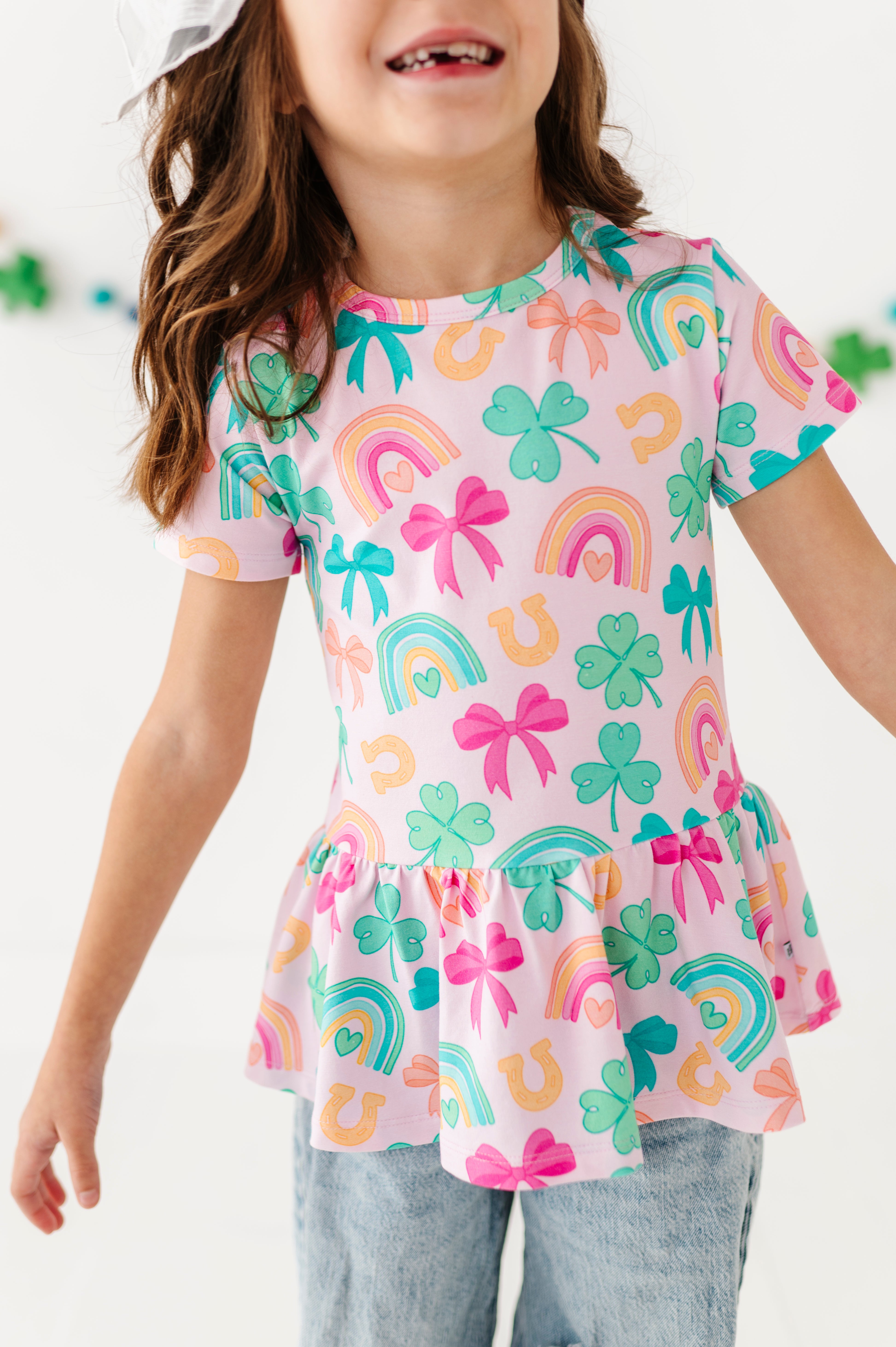 Child wearing a colorful St. Patrick's Day bamboo shirt on a white background 