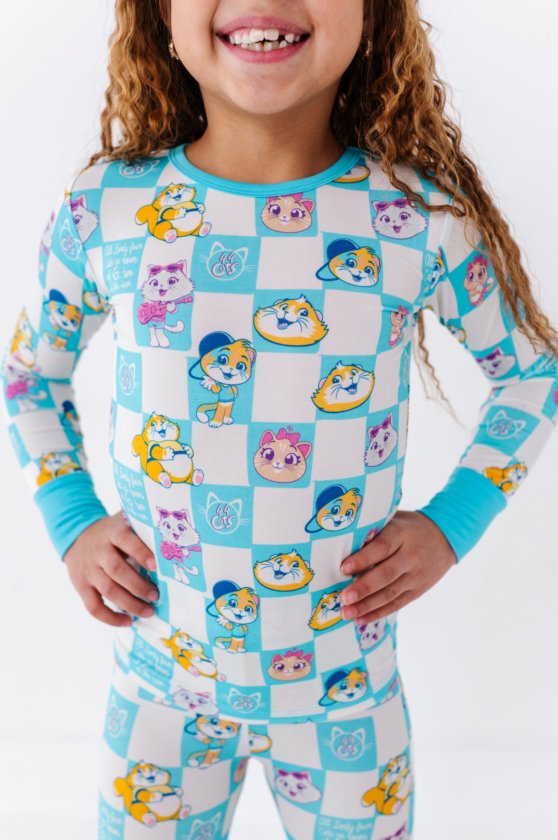 Child wearing a 44 Cats™ pajama set with cartoon character cats on a white background