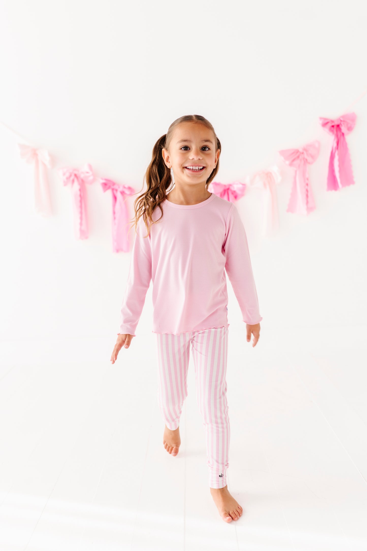 Girl wearing a pink ribbed lettuce hem top designed for sensitive skin