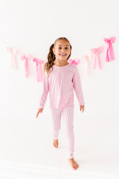 Girl wearing a pink ribbed lettuce hem top designed for sensitive skin