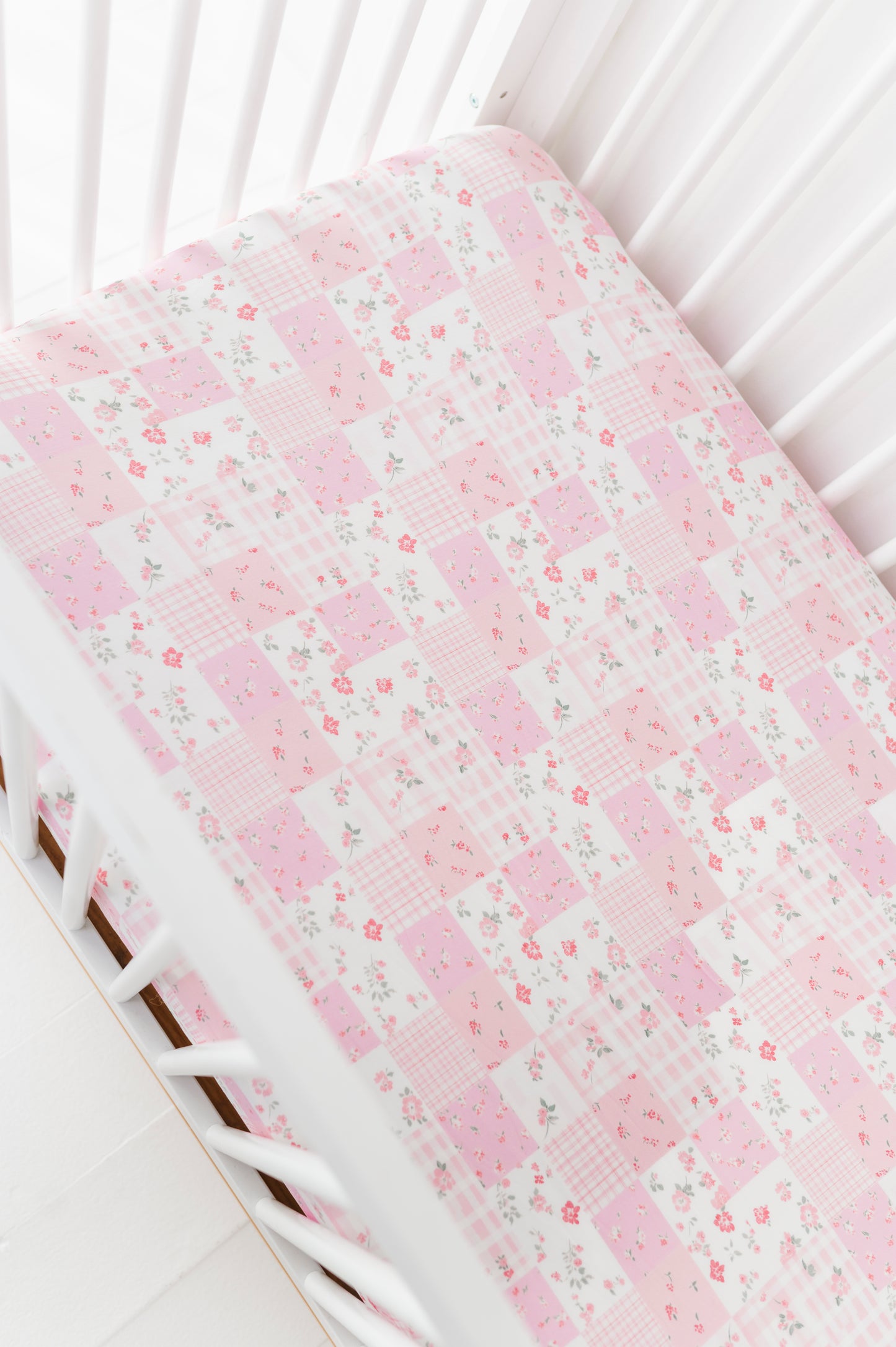 Floral-patterned bamboo crib sheet on a white crib