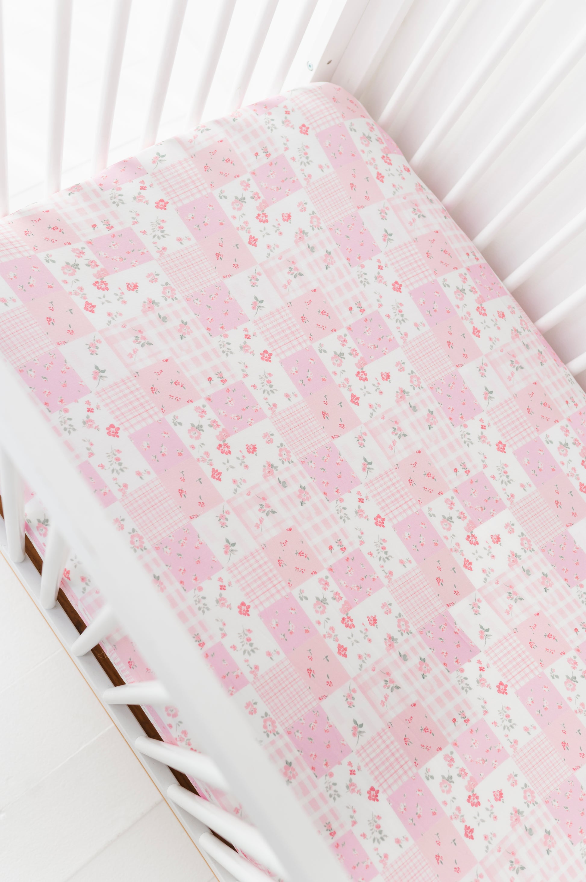 Floral-patterned bamboo crib sheet on a white crib