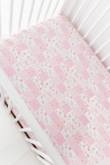 Floral-patterned bamboo crib sheet on a white crib