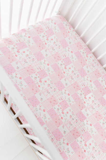 Floral-patterned bamboo crib sheet on a white crib