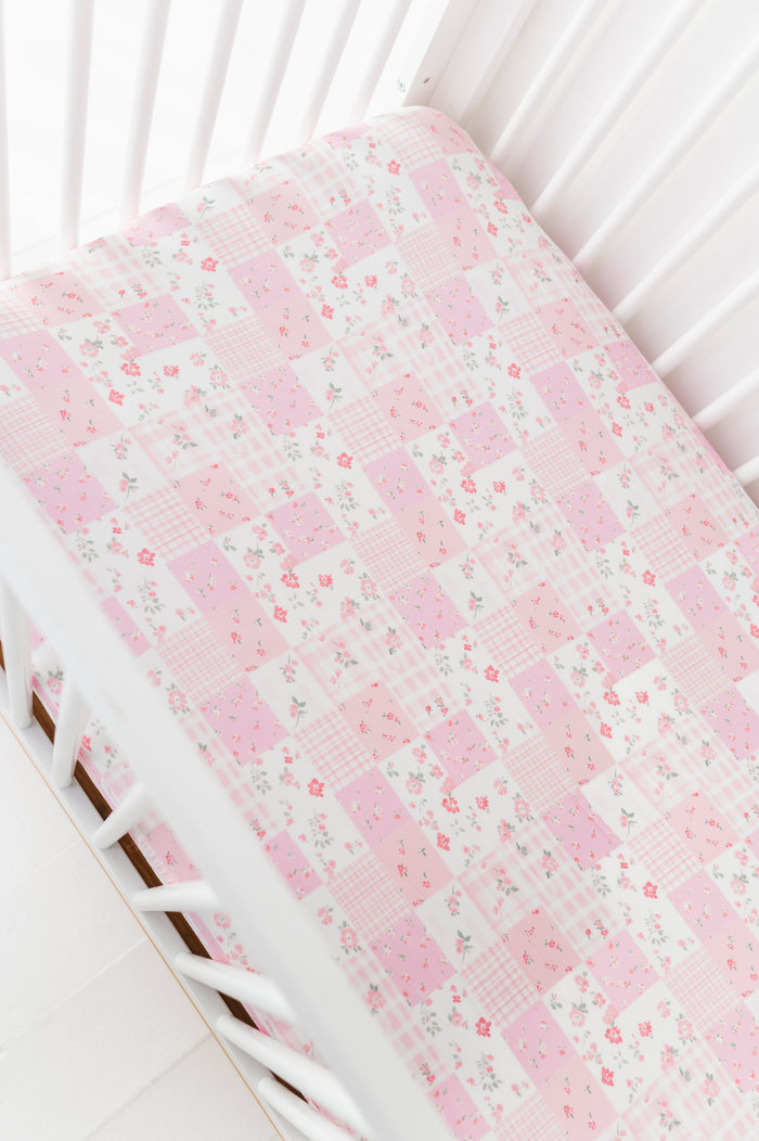 Floral-patterned bamboo crib sheet on a white crib