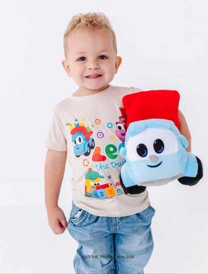 Toddler boy holding a plush Leo the Truck toy wearing a bamboo tee on a white background