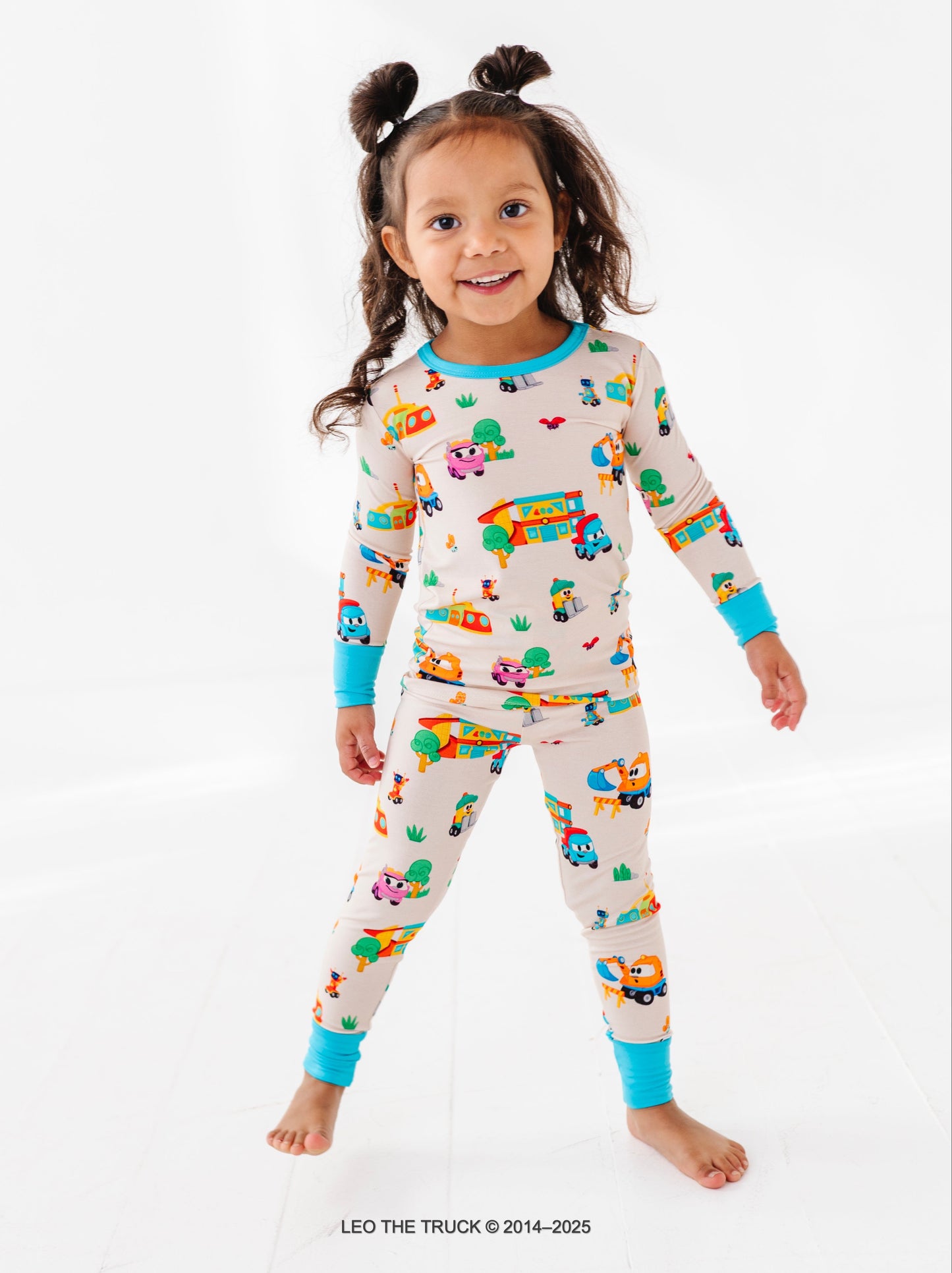 Toddler girl wearing bamboo Leo the Truck pajamas with on a white background