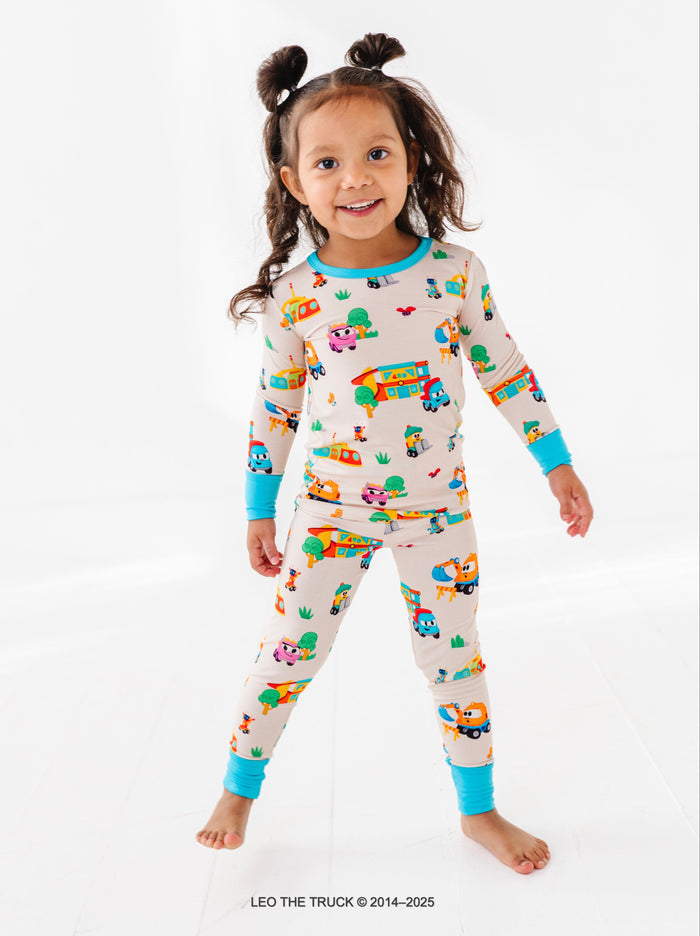 Toddler girl wearing bamboo Leo the Truck pajamas with on a white background