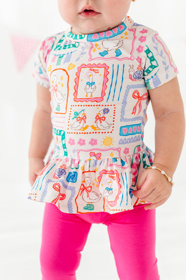 Child wearing a bamboo geese-themed peplum top with hot pink bamboo leggings