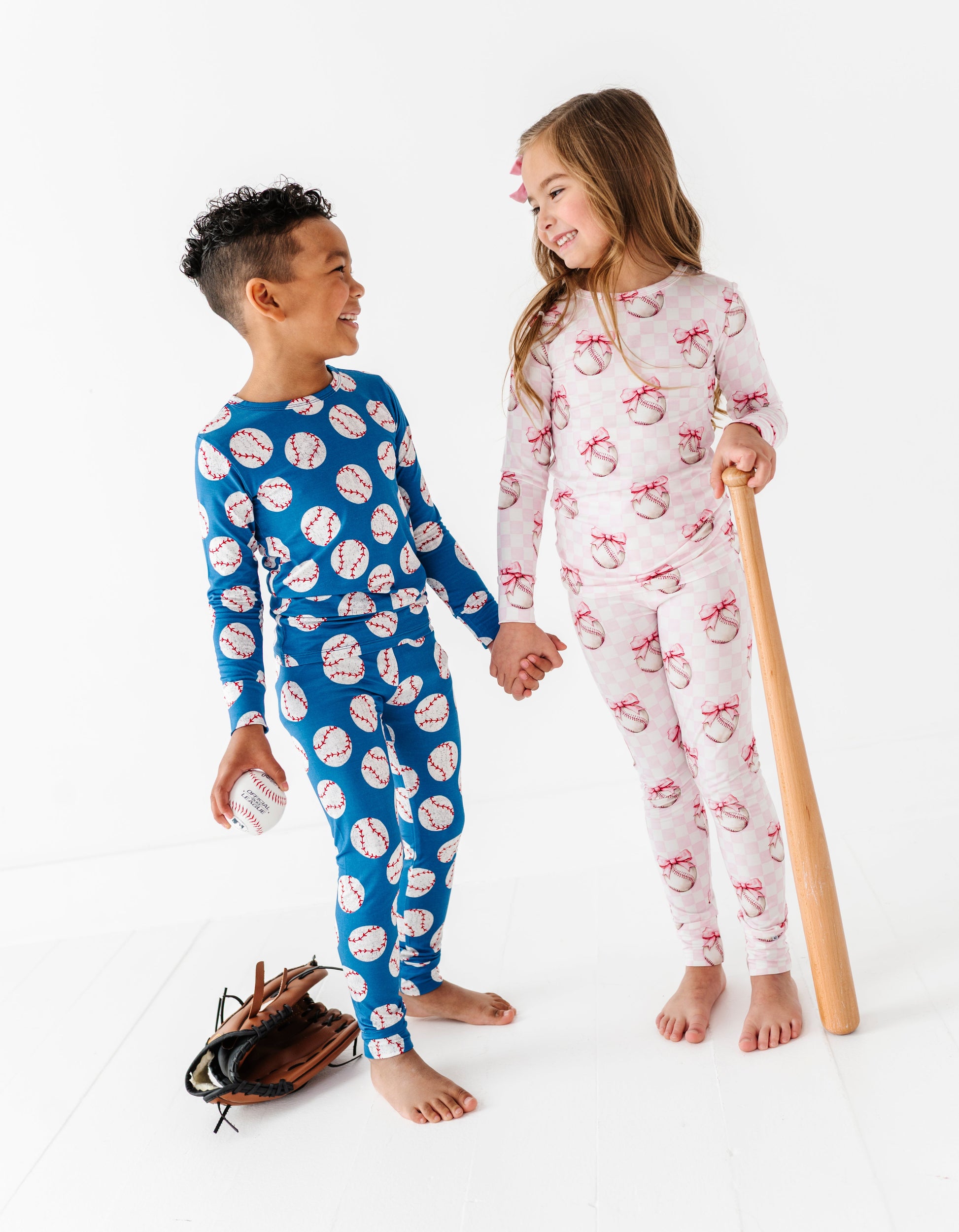 Siblings wearing patterned bamboo pajamas on a white background