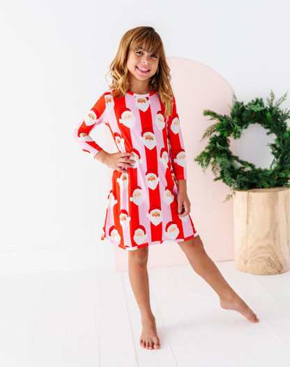 A young girl wearing a red and pink striped bamboo gown with pockets