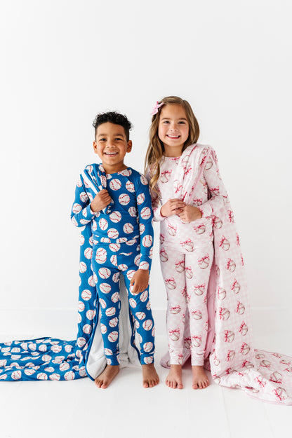 Two children wearing coordinating baseball bamboo pajamas on a white background