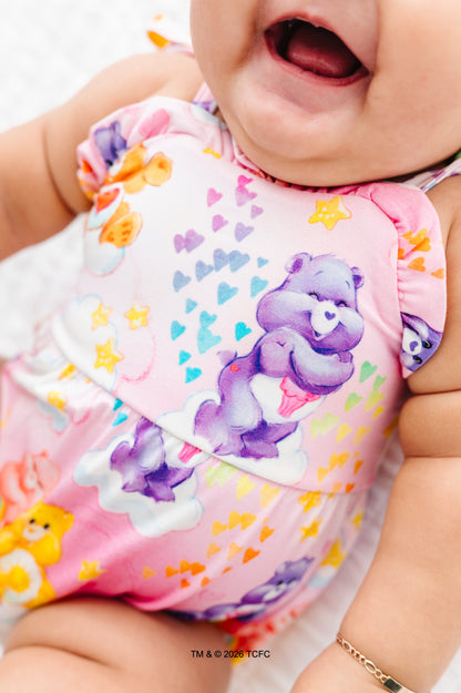 Baby wearing a colorful bamboo bubble romper with Care Bears™ on a white background