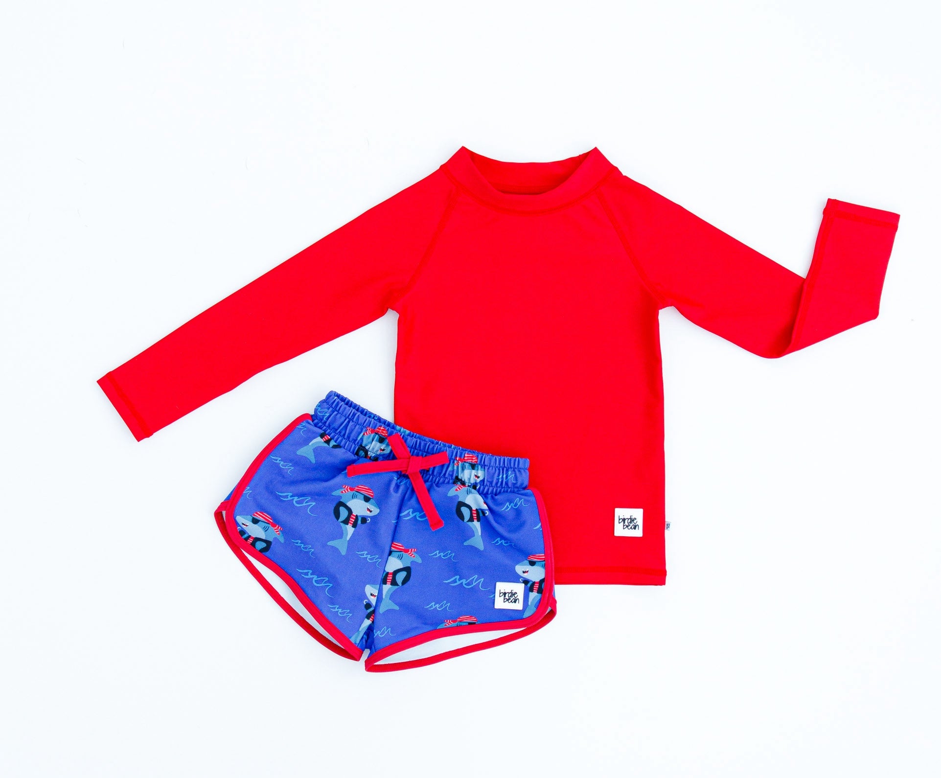 Sebastian Swim Shorties paired with crimson long-sleeve rash guard laid flat to show coordinating swim set