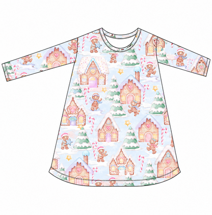 Front and back views of a long-sleeve baby dress with a light blue background and a whimsical gingerbread house pattern in pink, orange, and green.