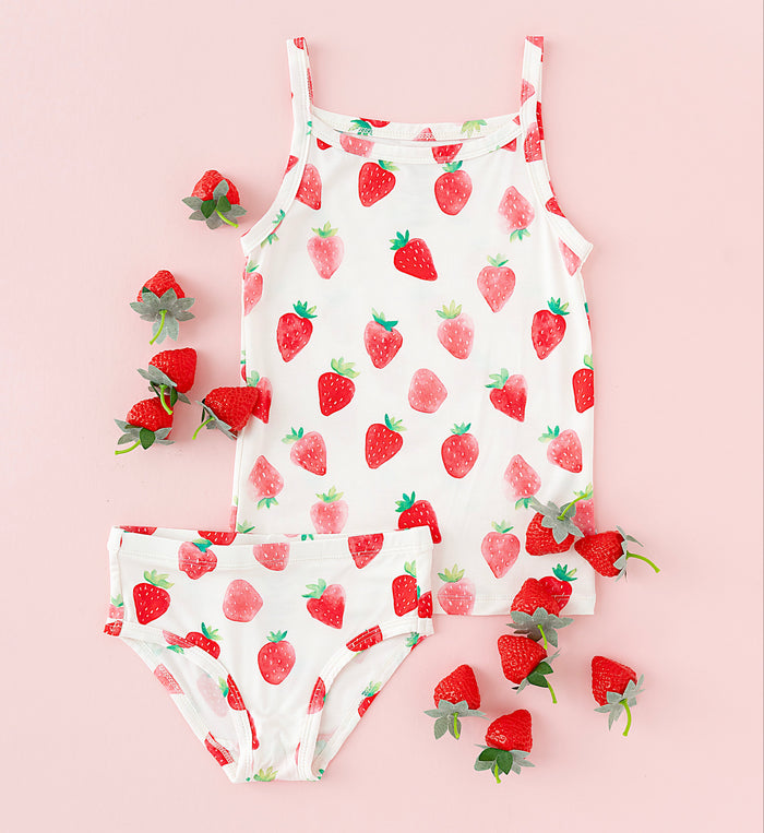 Children's strawberry-patterned cami and underwear set on a pink background
