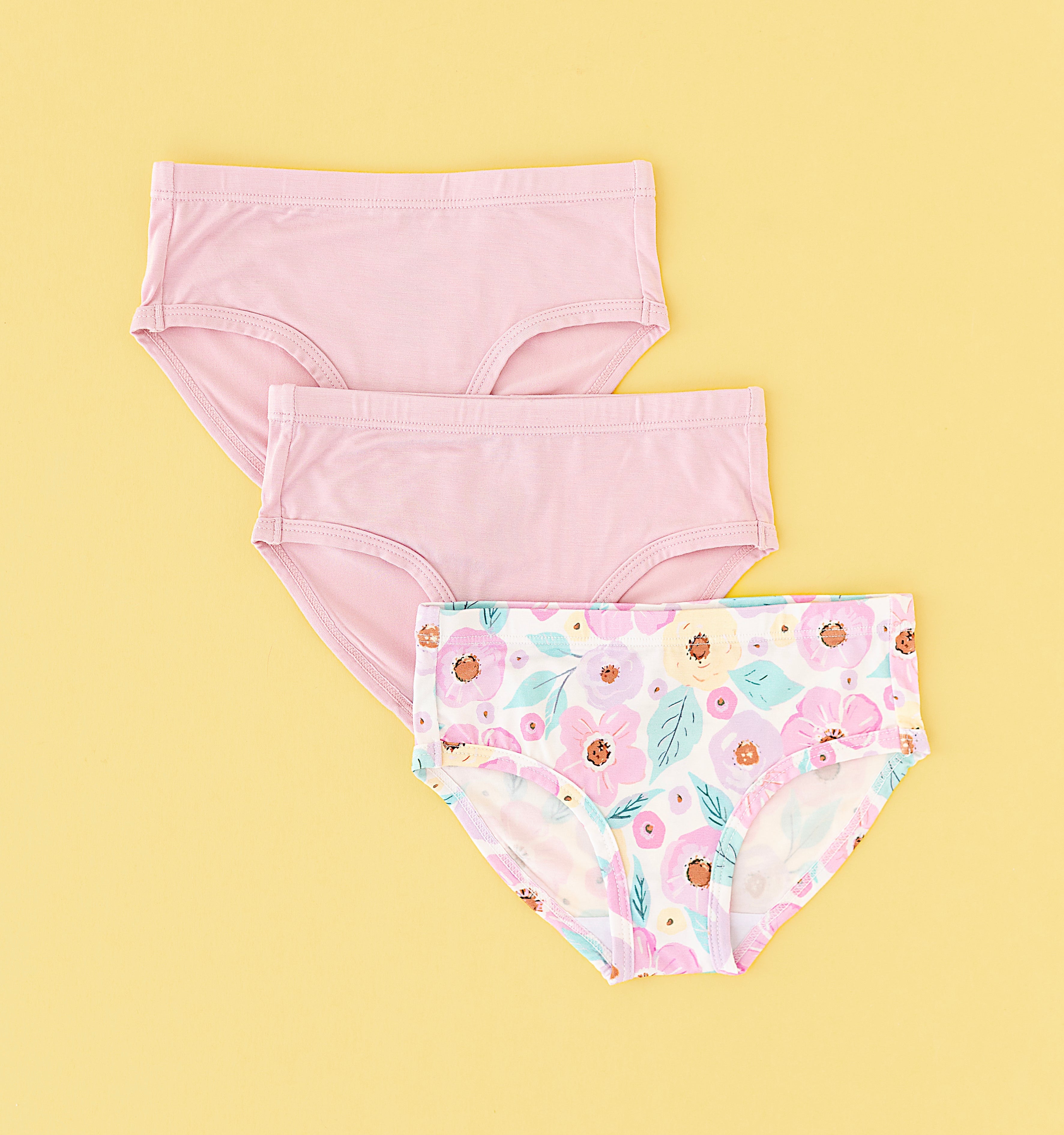 set of three underwear briefs for girls in two pink solids and a floral pattern on the third.