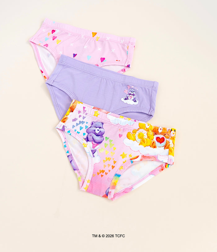Three pairs of children's bamboo underwear with colorful Care Bears™ designs on a beige background