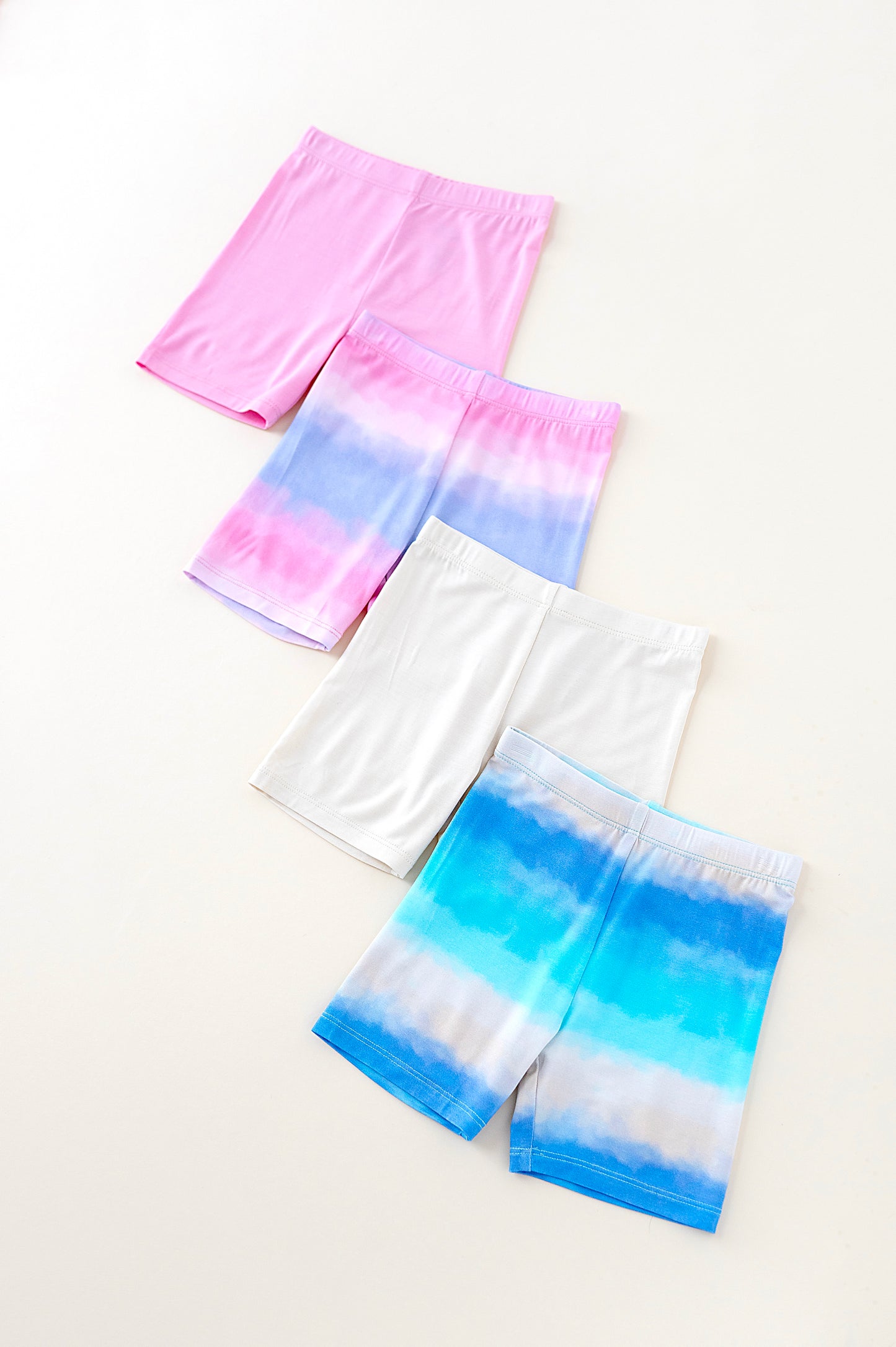 Set of three pairs of colorful shorts on a white background