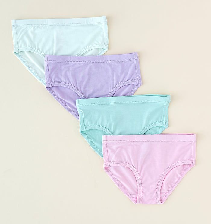 Four pairs of pastel-colored underwear on a beige background