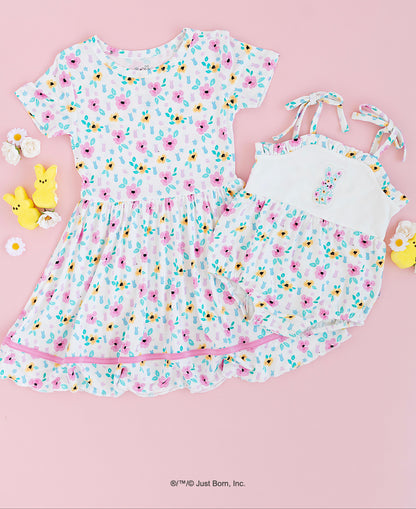 Children's PEEPS® floral dress and matching romper on a pink background with Peeps candy decorations.