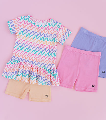 Children's clothing set with a colorful wavy patterned bamboo/cotton top and bamboo biker shorts in pink, purple, and yellow