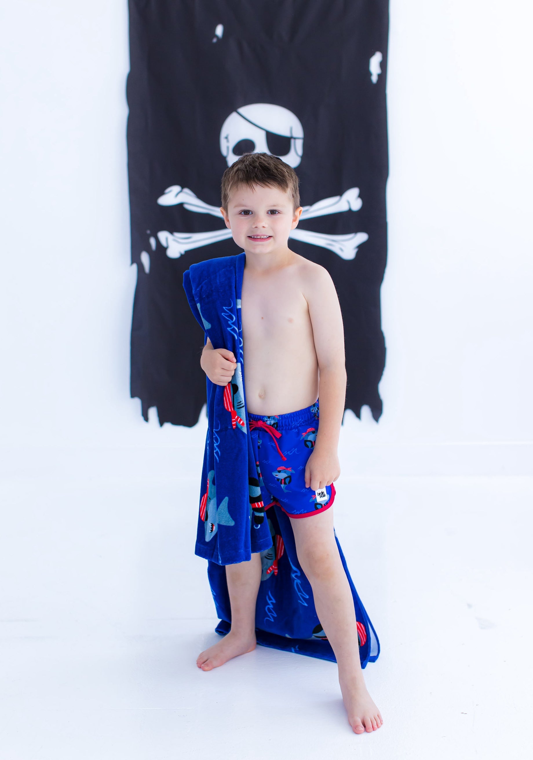 Child wearing Sebastian Swim Shorties paired with matching Sebastian beach towel