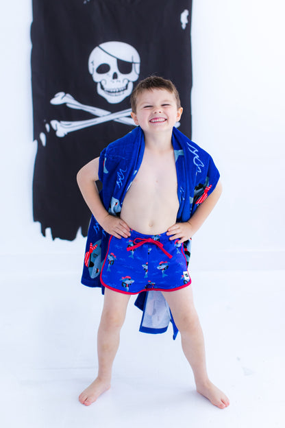 Child wearing Sebastian Swim Shorties paired with matching Sebastian beach towel, showcasing swim-ready fit
