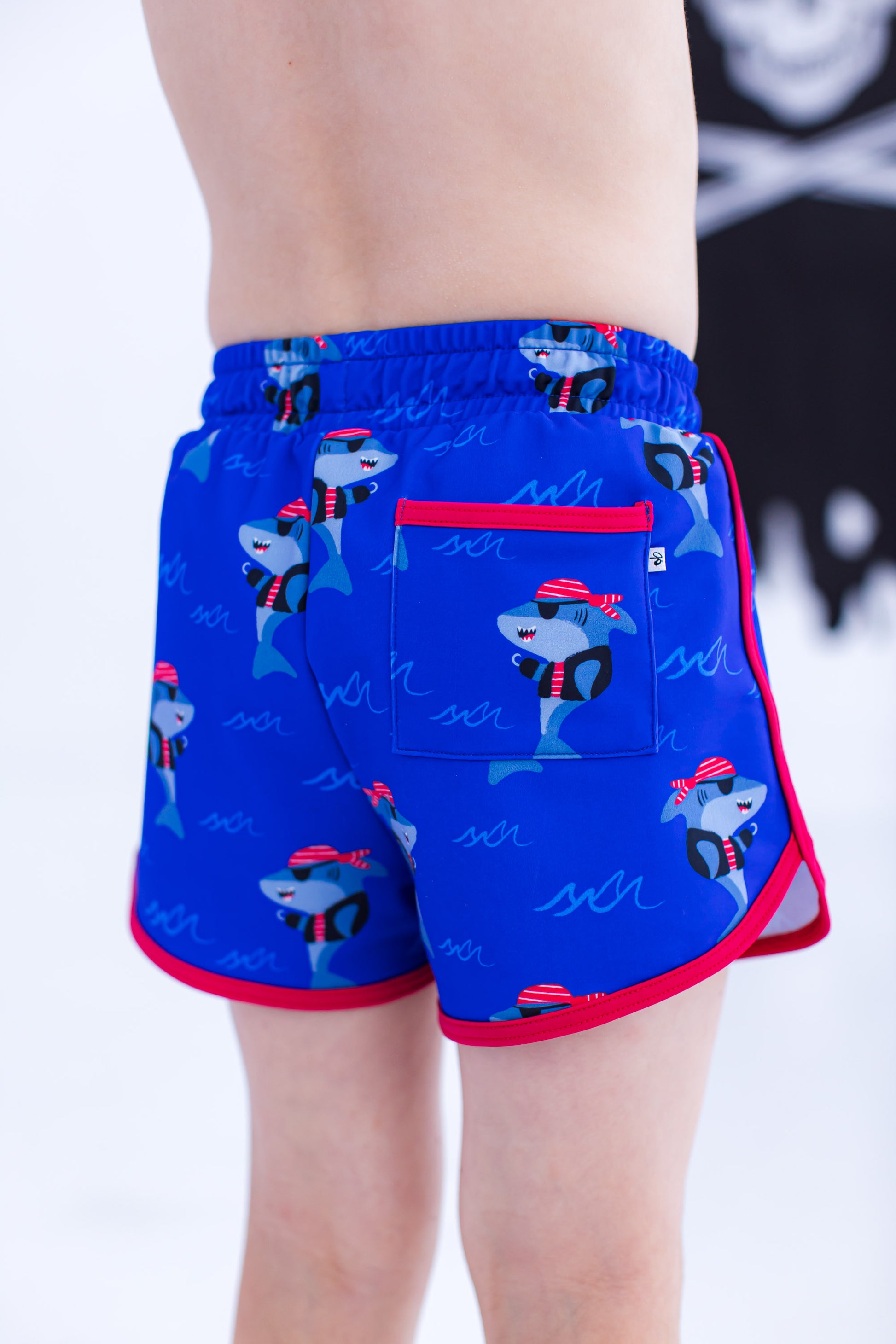 Back view of Sebastian Swim Shorties highlighting functional back pocket, elastic waistband, and shark print