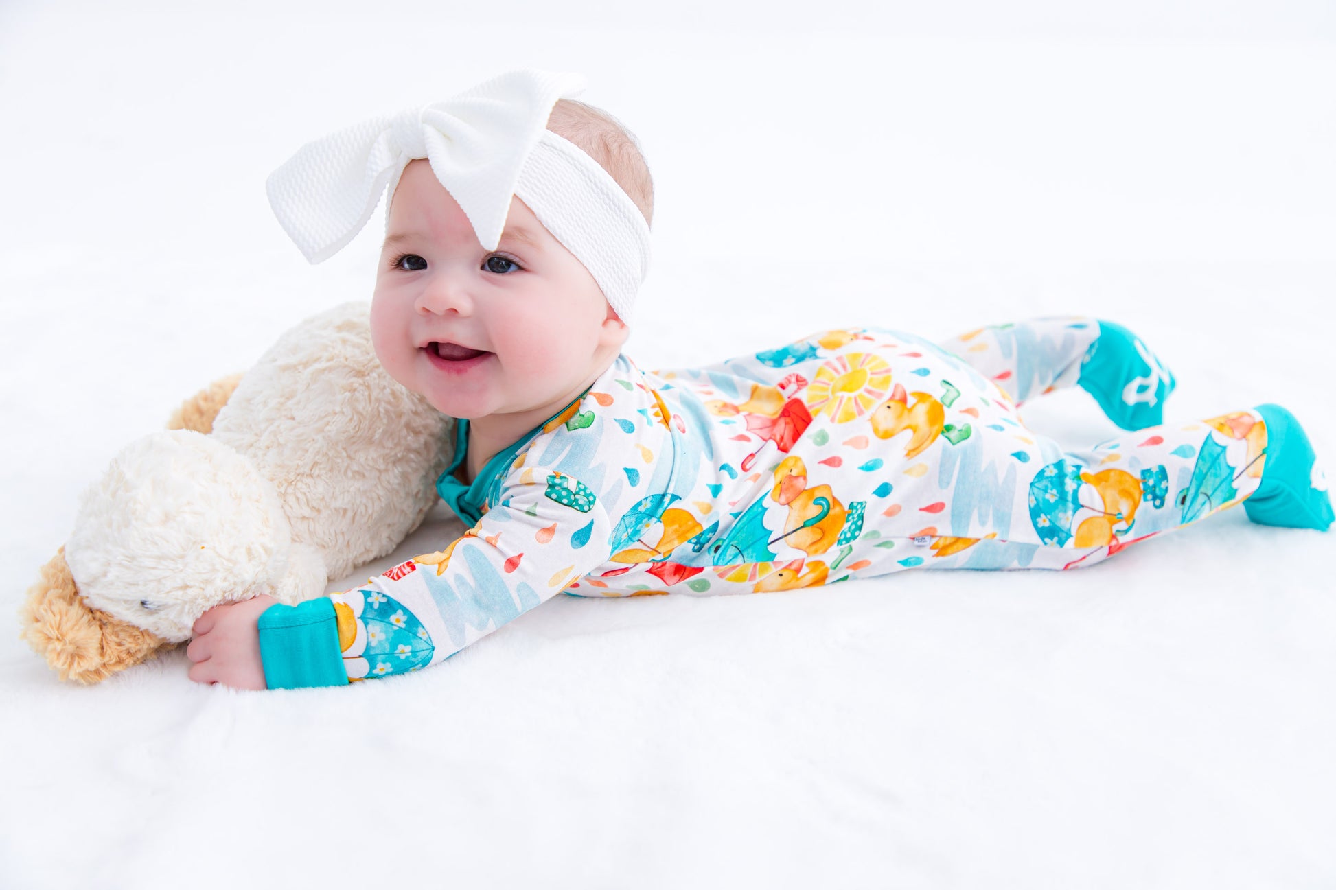 Baby wearing white headwrap bow styled with Birdie Bean bamboo apparel