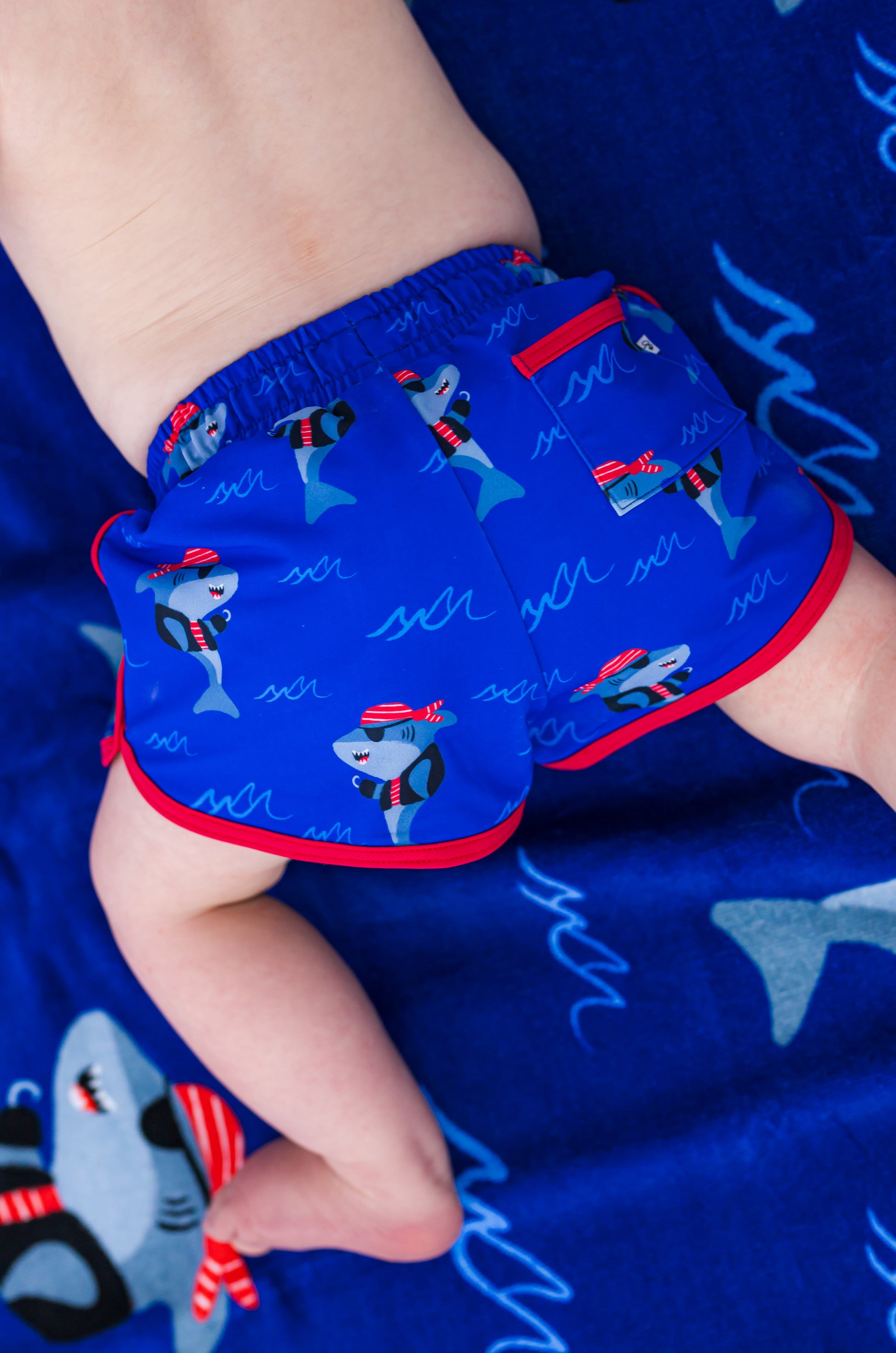 Back view of Sebastian Swim Shorties highlighting functional back pocket, elastic waistband, and shark print