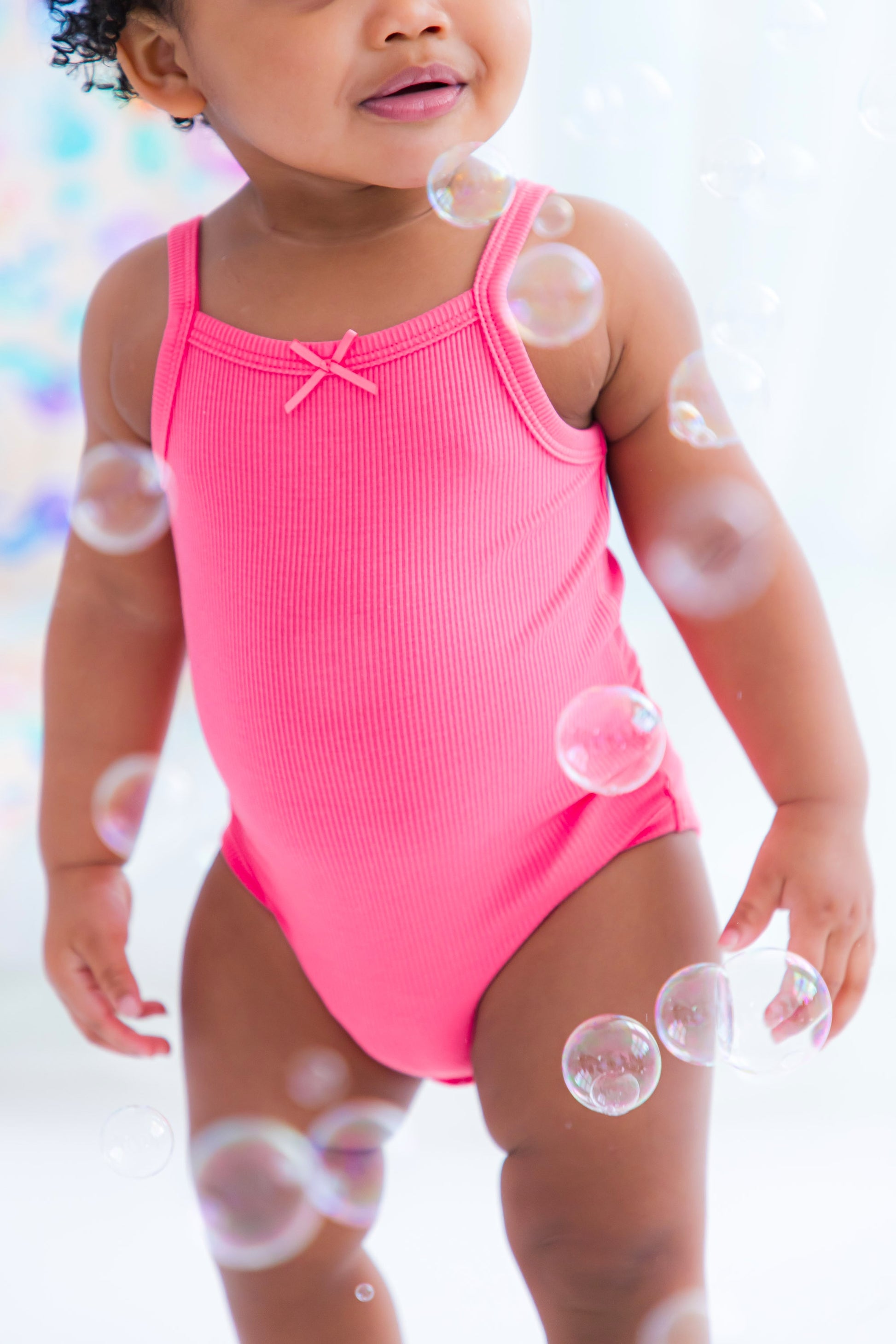 Baby wearing pink ribbed bamboo bodysuit tank