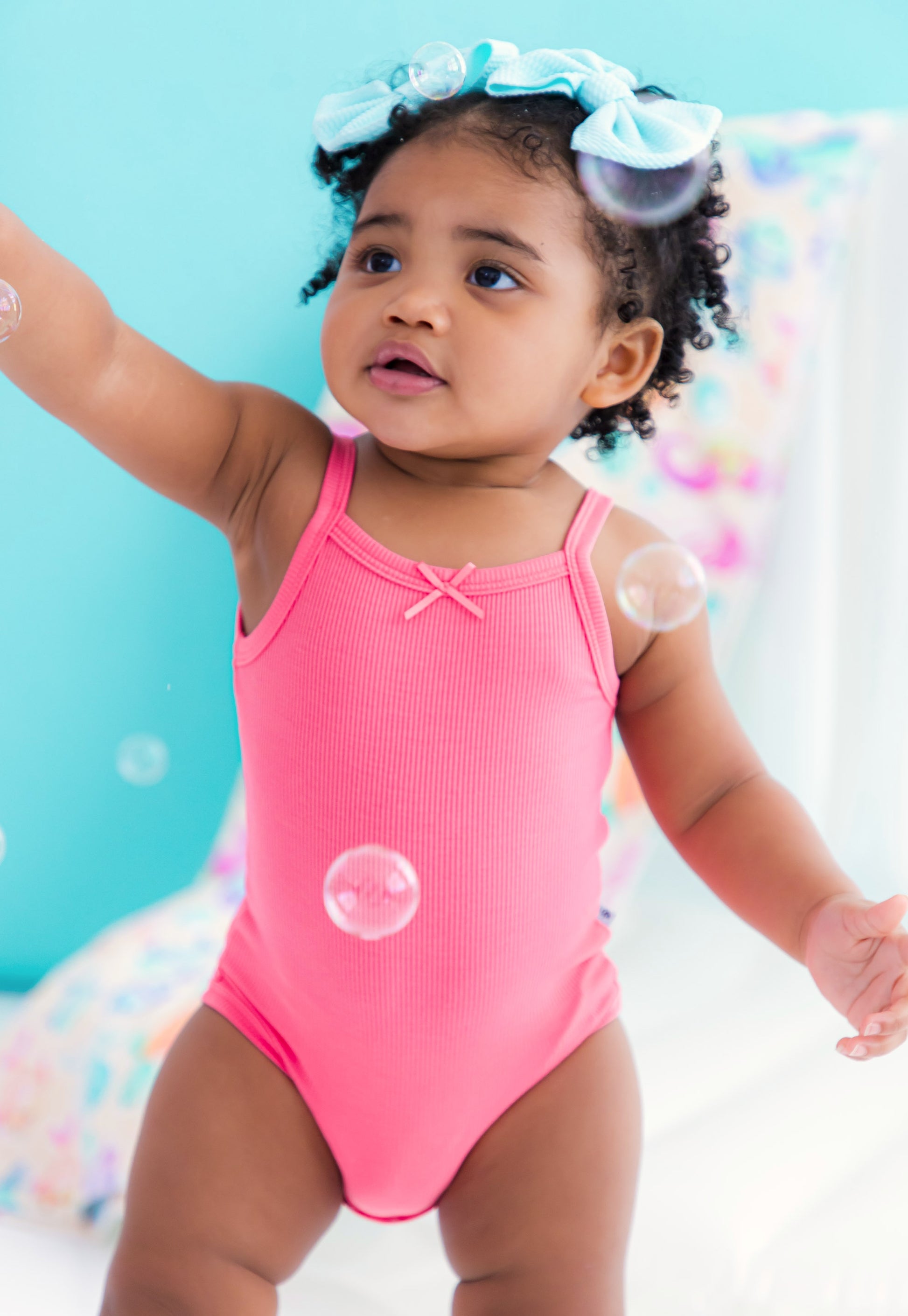 Baby wearing pink ribbed bamboo bodysuit tank