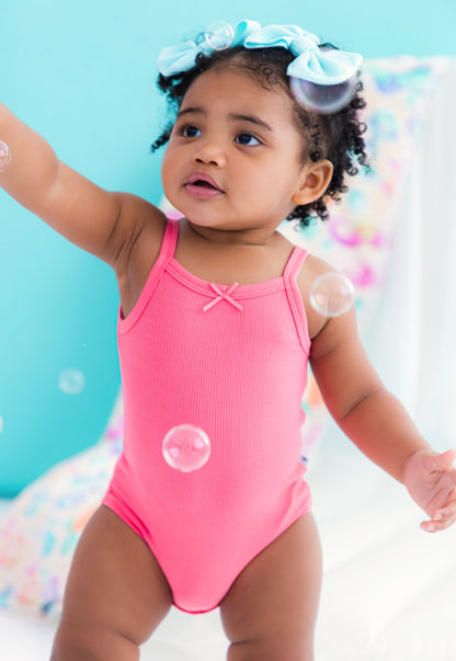 Baby wearing pink ribbed bamboo bodysuit tank
