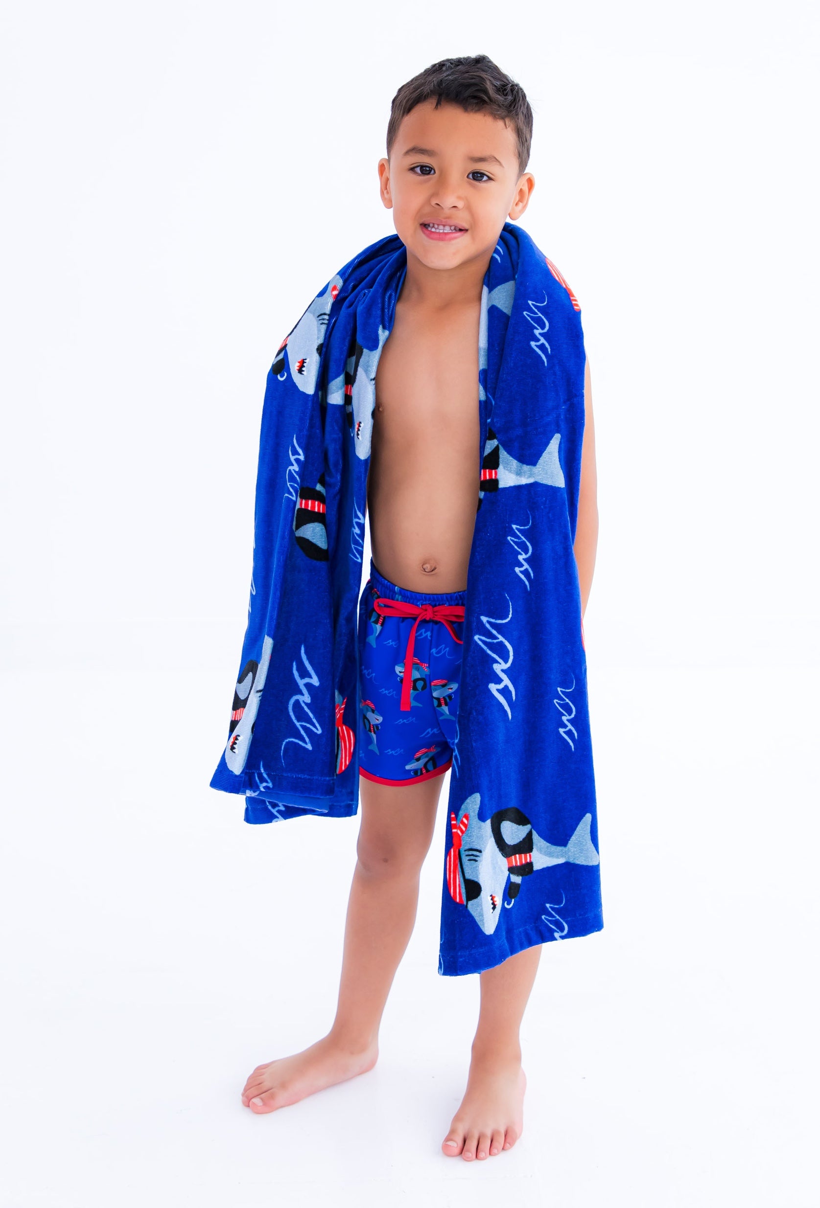 Child wearing Sebastian Swim Shorties paired with matching Sebastian beach towel, showcasing swim-ready fit